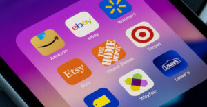 Smartphone screen showing popular retail and e-commerce apps including Amazon, Walmart, Target, Lowe’s, Best Buy, Etsy, Wayfair, eBay, and Home Depot, representing retailers expanding into major third-party marketplace platforms.