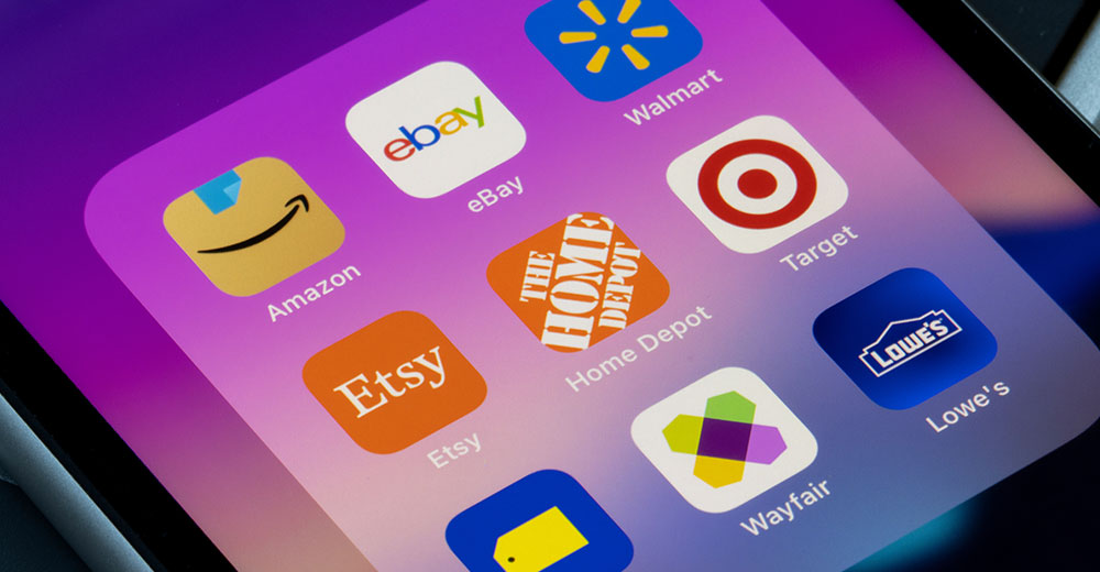 Smartphone screen showing popular retail and e-commerce apps including Amazon, Walmart, Target, Lowe’s, Best Buy, Etsy, Wayfair, eBay, and Home Depot, representing retailers expanding into major third-party marketplace platforms.